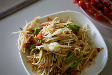 Spicy green papaya salad or Som Tum Thai food served on plate