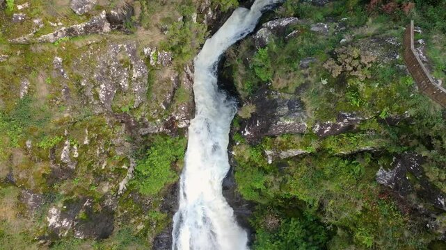 Waterfall Flowing Through Rocks. drone tilt-down shot