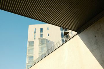 Facade of modern building with glass windows and underpass bridge