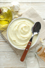 Mashed potatoes in bowl, bottle of oil and spices on wooden background, top view