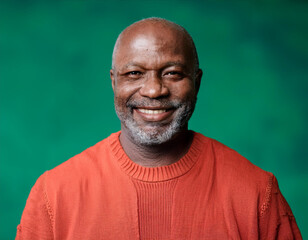 Obraz premium Studio Portrait of Handsome Mature Man Happily Smiling Against Green Background