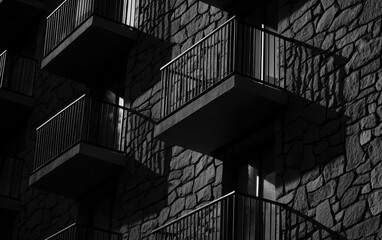 Fototapeta premium Detailed shot of historic stone architecture and balconies, captured in monochrome to emphasize the shadows, textures, and elegance of old-world design