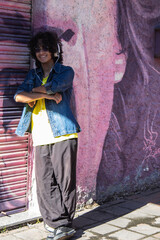 young urban man leaning on wall with headphones