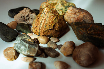photo of pebbles of various colors sitting together on a white background