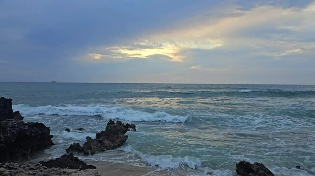 beach sunset landscape with sea waves clouds and rocks at the evening