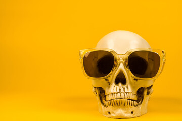 Cool Skull with Sunglasses for Horror-Themed Halloween Decor on a Bold Yellow Backdrop