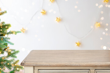 Empty wooden table top with blur background of Christmas fir tree and decorations