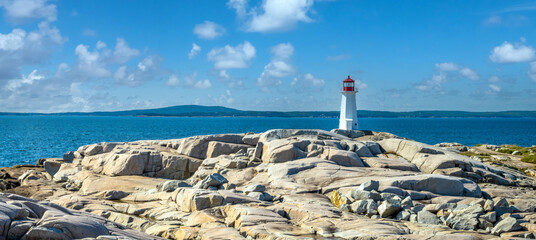 The famous lighthouse of Peggy's Cove, surrounded by stunning rock formations and boulders, Nova...
