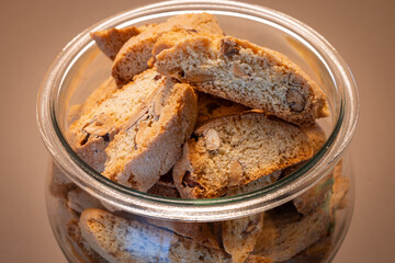 A top view of Italian almond biscotti stored in a glass jar The crunchy golden-brown cantucci with almond pieces emphasize their texture and freshness inside the container