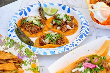 Mexican beef tacos with jalapenos, parsley, and fresh lime on ceramic surface