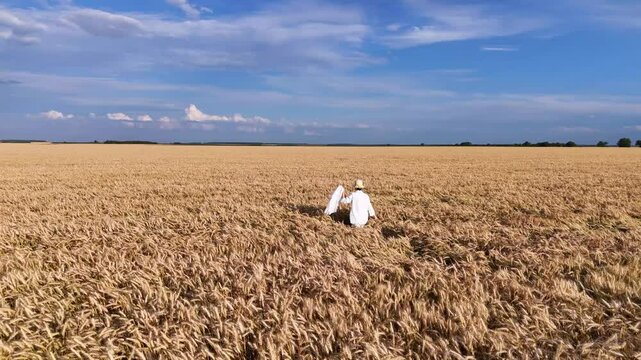 Girl in white dress walks and runs in field and wheat or cereal fields.