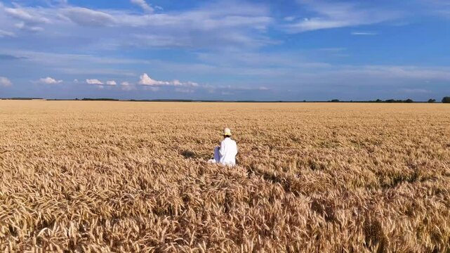 Girl in white dress walks and runs in field and wheat or cereal fields.