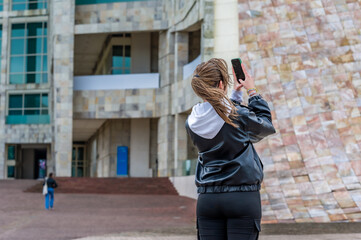 Woman photographing modern architecture in Santiago de Compostela, Spain