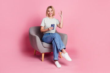 Photo of nice satisfied pretty girl wear stylish grey clothes sit comfy chair okey sign isolated on pink color background