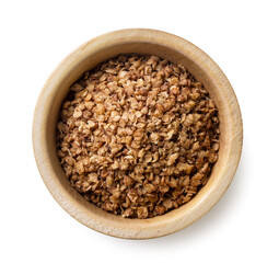Buckwheat flakes in a wooden plate on a white background. Top view