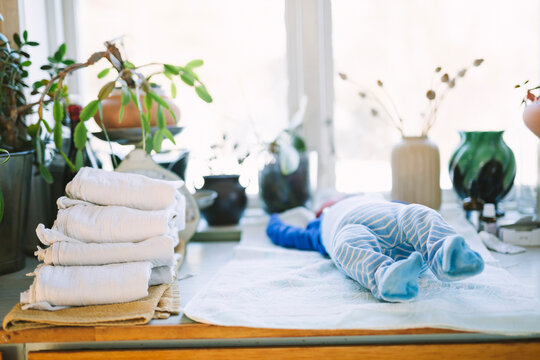 Stack of reusable diapers near new born baby lying down on table