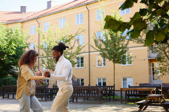 Couple practicing salsa dance in building back yard