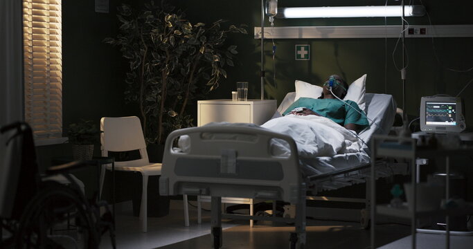 African woman in an oxygen mask is lying in a hospital room in a serious condition, in a coma, unconscious.
