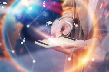 Young woman with smartphone in her hands. Outdoors. Global networking concept