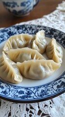 Glistening dumplings, perfectly shaped and adorned with a vibrant orange sauce, resting on an elegant black plate that reflects the light of its surroundings