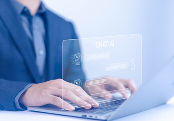 Businessman chatting with AI or artificial intelligence technology. A man uses a laptop computer to...