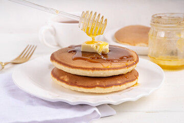 Pancakes with butter and honey or maple syrup drizzles