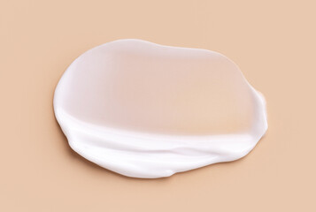 creamy smear of white cosmetic texture on beige background skin care concept