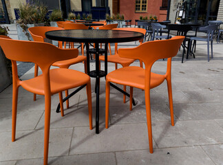 Round table and cozy colourful chairs in summer day
