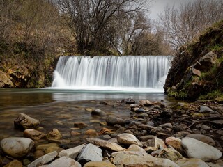 Serene waterfall cascading over rocks in a tranquil forest setting
