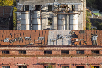 Old abandoned industrial building with rusty roof and decayed structure. Sheets of corrugated board...