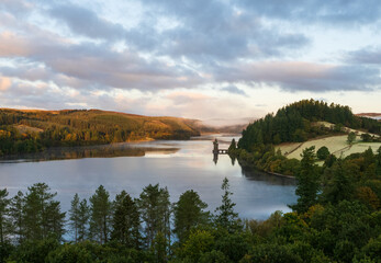Early morning light on t he lake, with forest surrounding it.