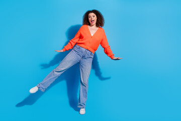Photo portrait of young latin funny lady with curly hairstyle in orange cardigan dancing boogie...