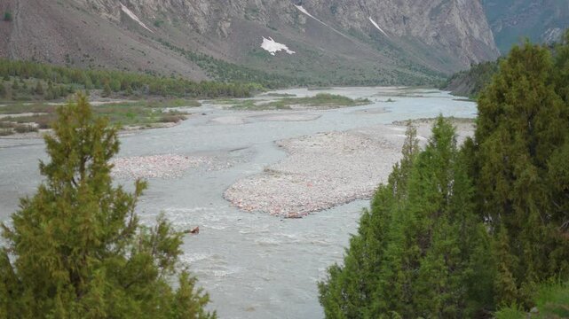 4K Closeup shot of river Bhaga flowing in the riverbed besides the mountain as seen from Jispa village in Lahaul and Spiti district, Himachal Pradesh, India. River flowing in the mountains background.