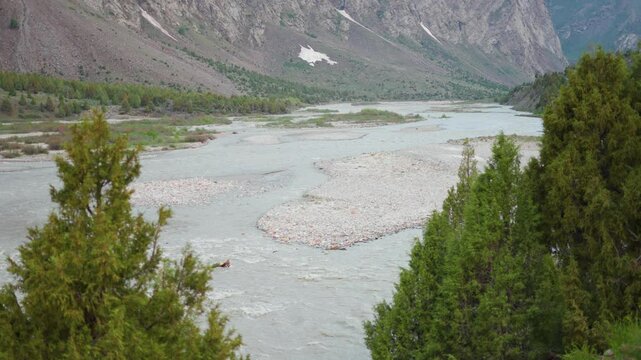 4K Closeup shot of river Bhaga flowing in the riverbed besides the mountain as seen from Jispa village in Lahaul and Spiti district, Himachal Pradesh, India. River flowing in the mountains background.