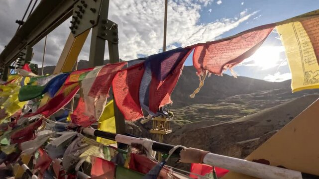 Colorful Buddhist prayer flags fluttering in wind, strung along Chicham Bridge
