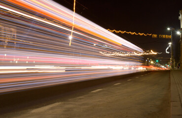 A street at night with a bright light in the background. Is blurry, giving the impression of...