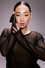 Fashion, asian woman, black sheer top, posing, hands on face an elegant asian woman wearing a black...
