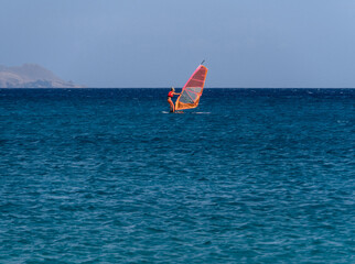 Windsurfing in the Mediterranean Sea off the coast of Mykonos Island in Greece