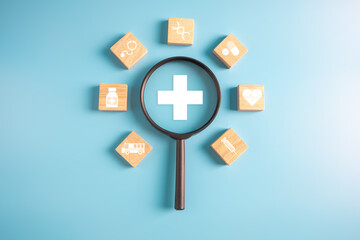 Magnifier and Wooden block with medical icon for medical healthcare check and health insurance concept