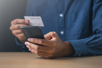 Businessman using mobile phone and holding credit card. Digital information technology and cyber security concept.