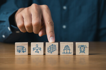 Businessman and wooden blocks of logistics icons and supply chain management.