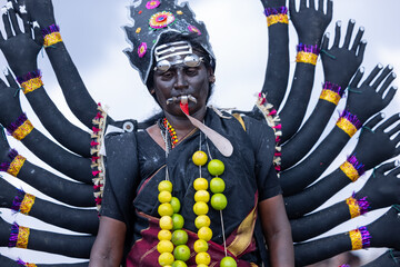 Kulasai Dasara, Portrait of indian woman with painted face and dressed as hindu god kali to perform...