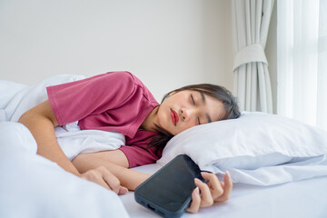 Asian young woman sleeping calmly on bed in bedroom at home during morning.