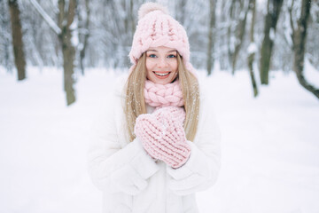 Happy woman walks in the snow in the park, beautiful view in winter.
