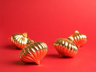 Golden Christmas baubles on a red background with space for your text