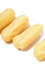 Neatly stacked mini cream puffs (sus kering) in a thumb-sized, golden-yellow shape. Photographed on a white background. Perfect as a light snack.