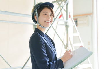 建設現場で図面を見る女性ビジネスマン（スーツ・工事・現場監督）