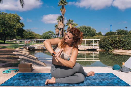 Woman practicing Ardha Matsyendrasana in an outdoor setting