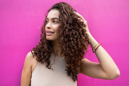 Smiling Brazilian businesswoman against pink background