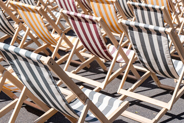 Lines of striped beach chairs in vibrant sunlight